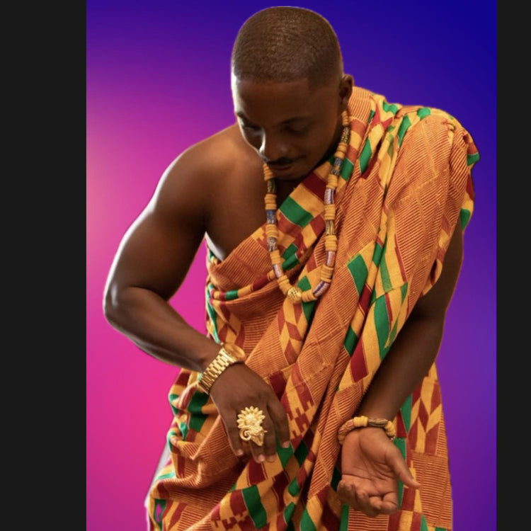 Man wearing jewellery with Krobo beaded necklace and bracelet and traditional Kente cloth from Ghana.