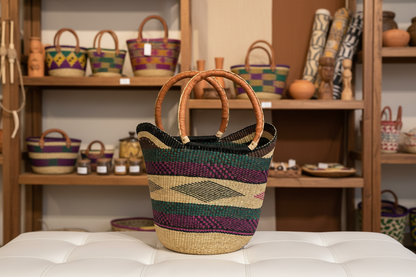 Woven basket with wooden handles on a white surface, with shelves of similar baskets in the background.